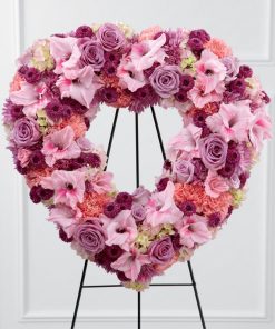 Heart shaped funeral standing spray with lavender roses pink carnations purple chrysanthemums pink gladiolus and hydrangea on easel stand