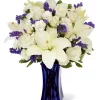 White Lily and Blue Flower Bouquet with white Asiatic lilies, ivory roses, cream spray roses, blue statice and dark blue vase