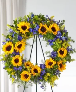 Bright Rays Wreath with yellow sunflowers blue delphinium solidago English ivy springerii fern and wire easel