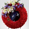 Patriotic American flag funeral wreath spray with blue iris red carnations white lilies flag inspired fabric and easel stand
