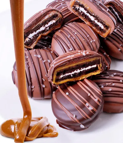 Caramel Sea Salt Chocolate Covered OREO Cookies covered in caramel, dipped in Belgian milk chocolate, topped with sea salt, and finished with chocolate drizzle