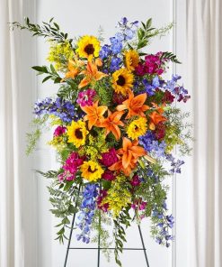 Colorful funeral standing spray with sunflowers lilies delphinium carnations and stock
