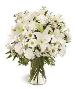 Tranquil Light Arrangement all-white sympathy flowers in a clear glass vase with white lilies, carnations, alstroemeria, daisies, and button poms for funeral, memorial, or condolence delivery.
