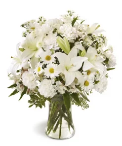 Tranquil Light Arrangement with white lilies, carnations, alstroemeria, daisies and button poms in a clear glass vase for sympathy flower delivery