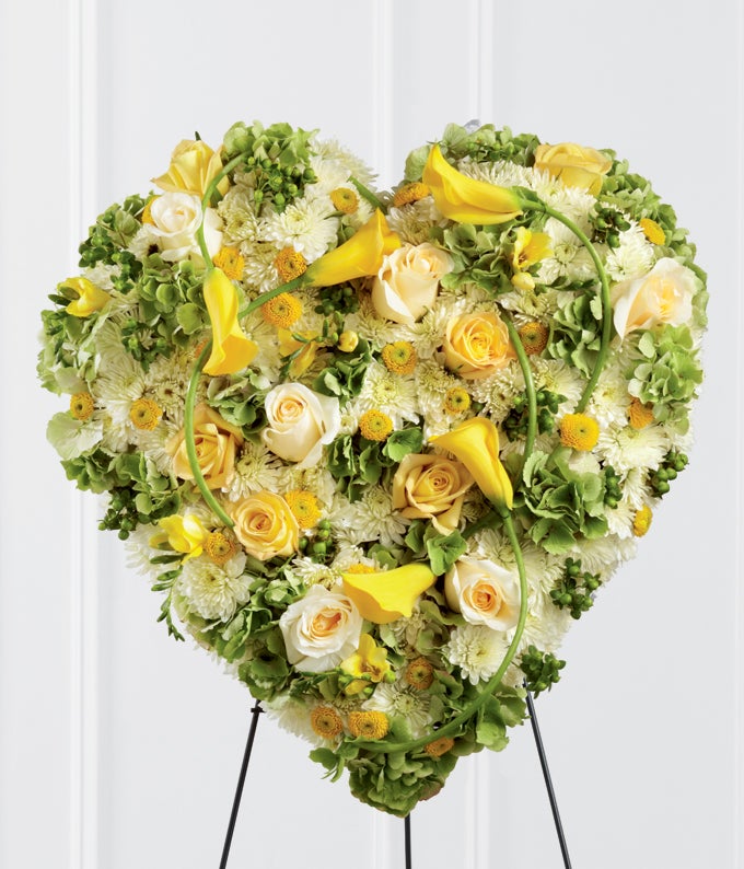 Golden heart funeral standing spray with yellow roses mini calla lilies freesia green hydrangea cream roses white chrysanthemums hypericum berries and easel stand