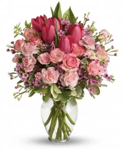 Blushing rose and tulip bouquet with pink roses, hot-pink tulips, pale-pink carnations, waxflower and greenery in a glass vase